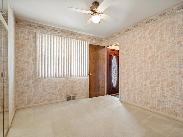 carpeted spare room featuring a wealth of natural light and wallpapered walls