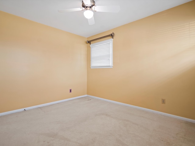 unfurnished room with baseboards, light carpet, and a ceiling fan