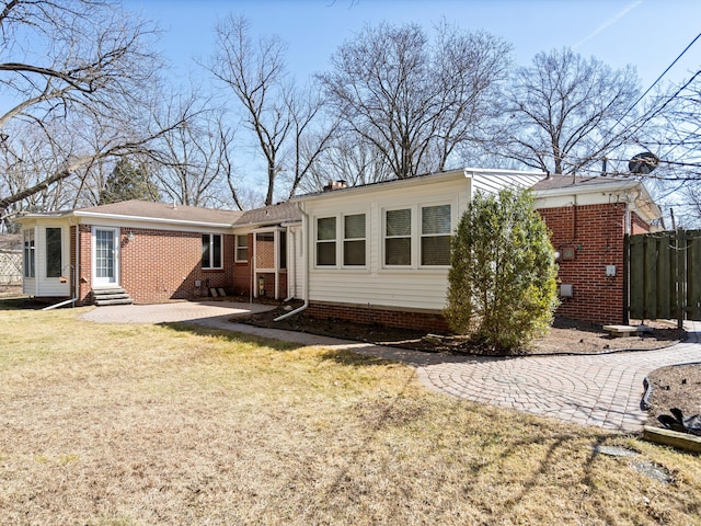 view of front of home featuring entry steps, fence, a front yard, crawl space, and brick siding