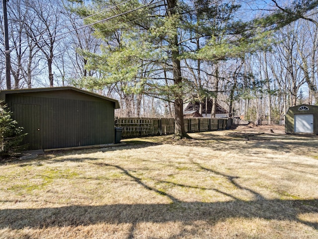 view of yard with a shed, an outdoor structure, and fence