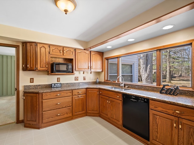 kitchen with a sink, brown cabinets, black appliances, and recessed lighting