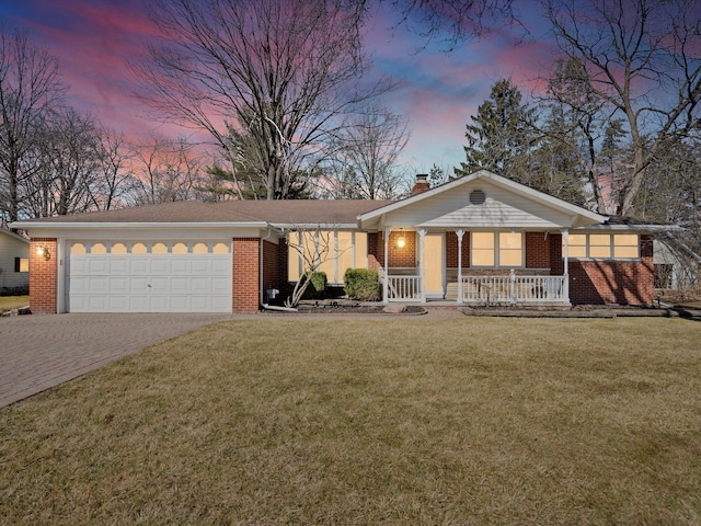 view of front facade with brick siding, covered porch, a chimney, decorative driveway, and an attached garage