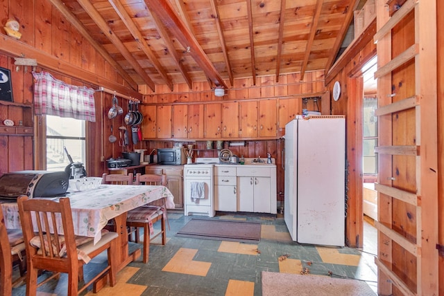 kitchen with wooden ceiling, wooden walls, vaulted ceiling, freestanding refrigerator, and tile patterned floors