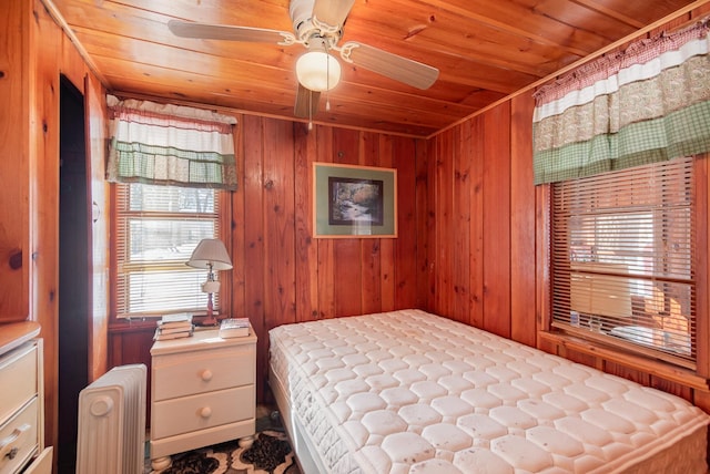 bedroom featuring wood walls, radiator heating unit, and wood ceiling