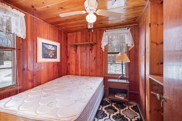 bedroom with wooden ceiling and wood walls