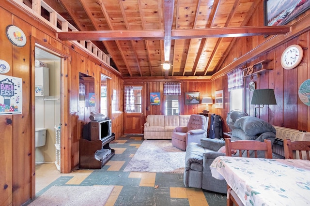 living room with vaulted ceiling with beams, wood walls, and wood ceiling