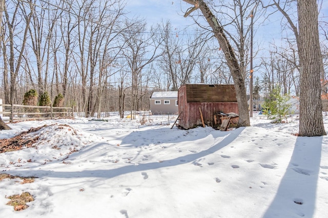 yard covered in snow featuring an outdoor structure and a storage unit