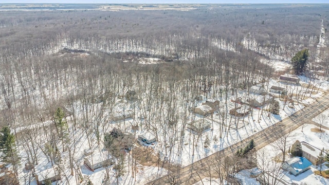 snowy aerial view featuring a wooded view