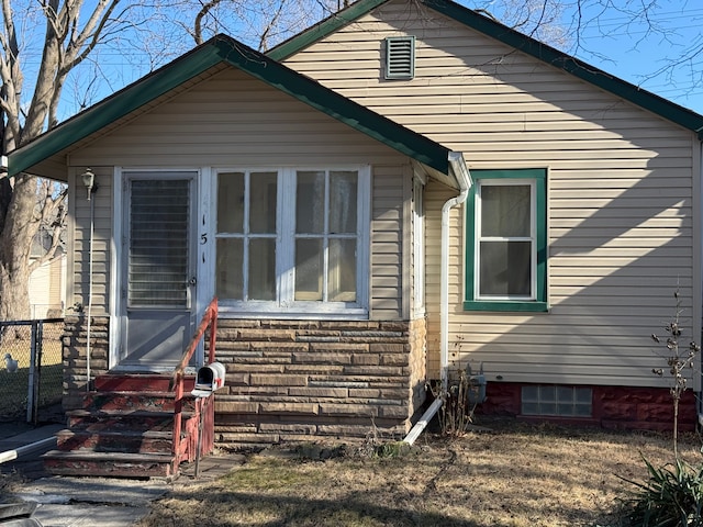 bungalow-style home featuring entry steps and fence