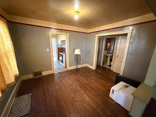 unfurnished bedroom with baseboards, visible vents, and wood finished floors