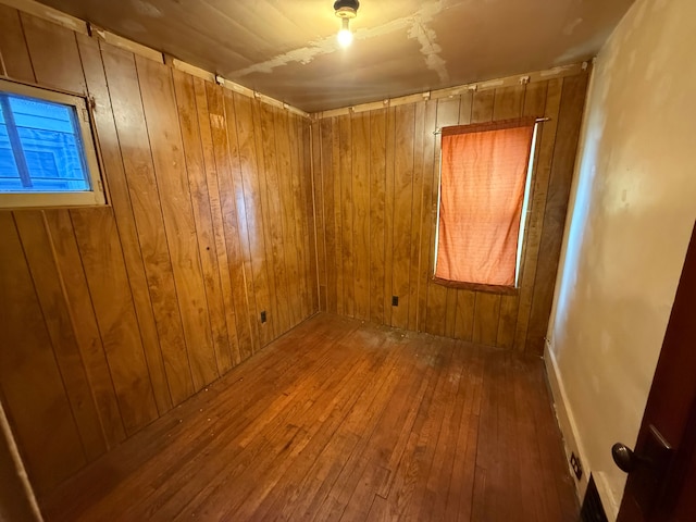 empty room with wood-type flooring and wooden walls