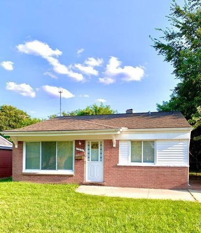 view of front facade featuring a front yard and brick siding