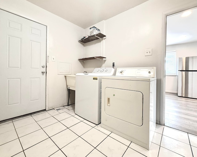 laundry area with washing machine and dryer, laundry area, and light tile patterned floors