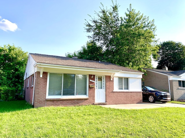 view of front facade with brick siding and a front lawn