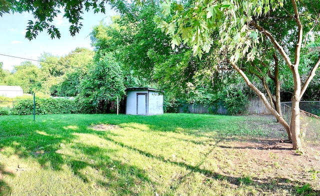 view of yard featuring a storage shed, an outdoor structure, and a fenced backyard