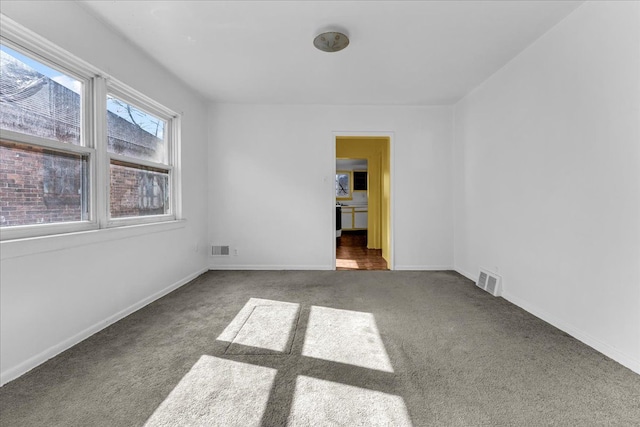 carpeted empty room featuring visible vents and baseboards