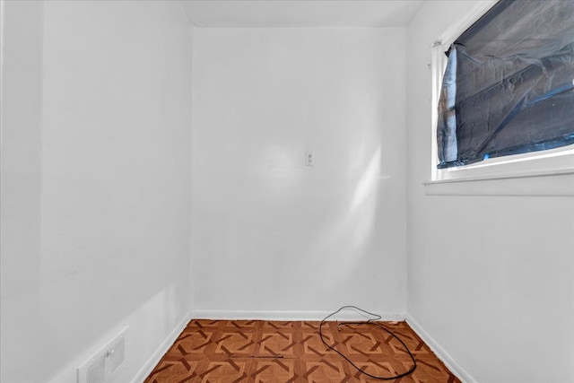 unfurnished room with visible vents and baseboards