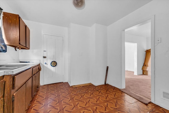 laundry room with a sink and baseboards