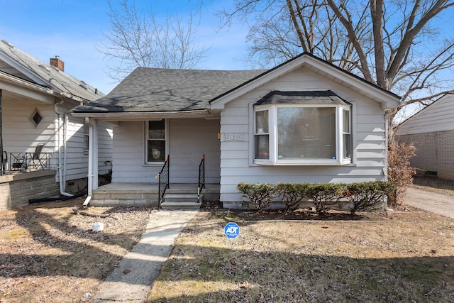 bungalow-style house featuring a porch and roof with shingles