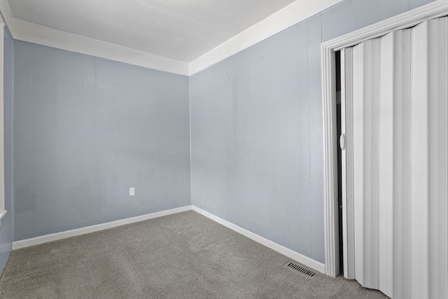 empty room featuring visible vents, baseboards, and carpet floors