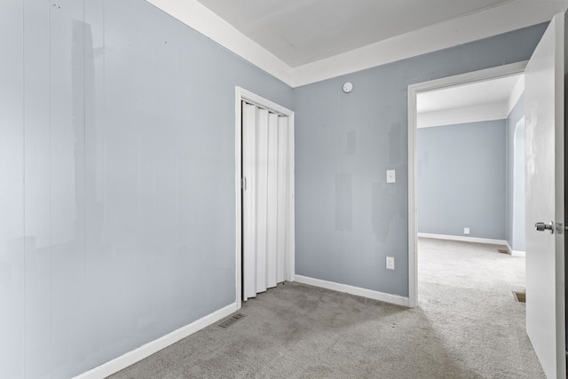 unfurnished bedroom with a closet, visible vents, baseboards, and carpet floors