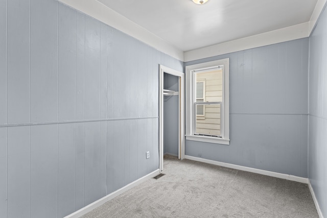 spare room with visible vents, baseboards, and carpet