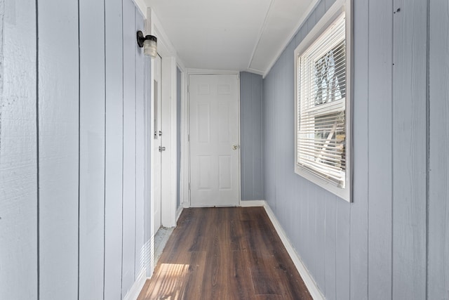 corridor featuring baseboards and dark wood-style floors