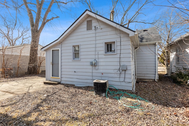 back of house with cooling unit, fence, and roof with shingles