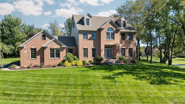 view of front facade with a front yard and brick siding