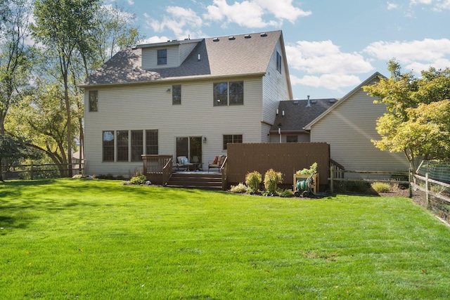 back of house with a wooden deck, fence, and a yard