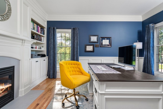 office space with ornamental molding, plenty of natural light, and a fireplace with flush hearth