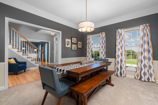 carpeted dining area featuring baseboards, stairs, and ornamental molding