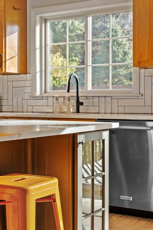 kitchen with a wealth of natural light, wine cooler, decorative backsplash, and stainless steel dishwasher