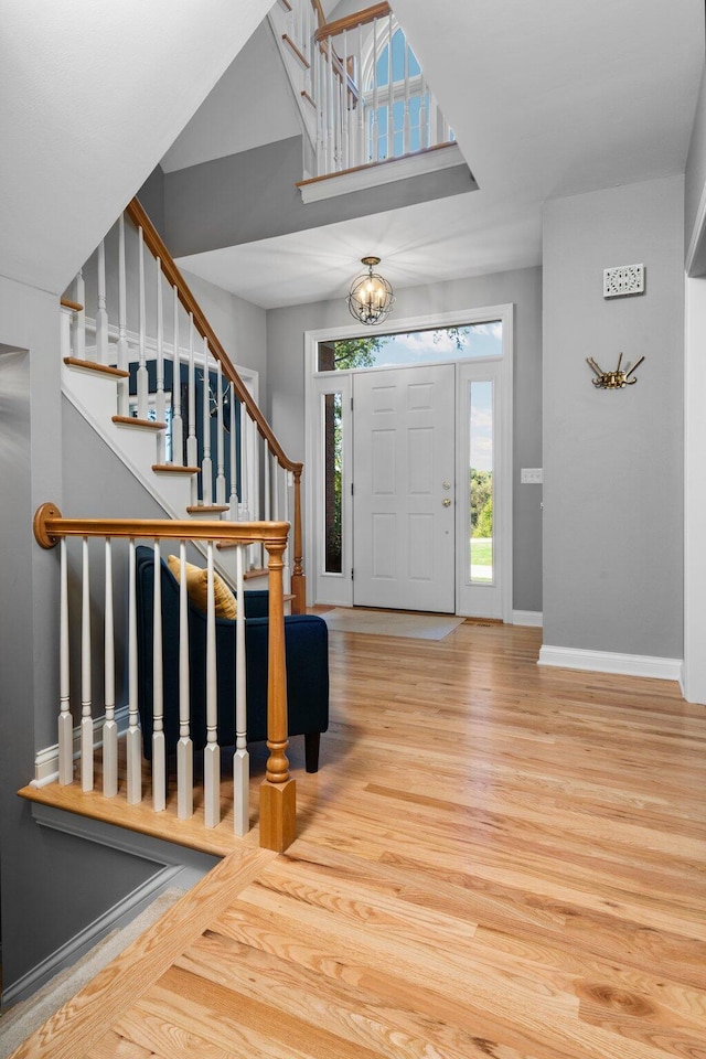 entryway with stairs, baseboards, and wood finished floors