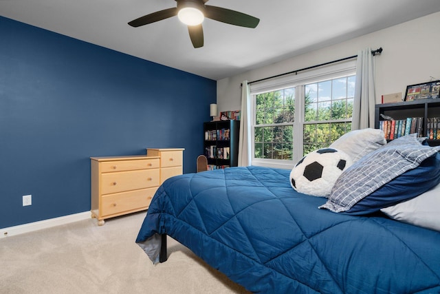 carpeted bedroom with a ceiling fan and baseboards