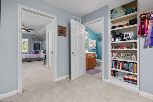 corridor with carpet, visible vents, vaulted ceiling, and baseboards