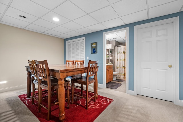 dining room with a paneled ceiling, carpet, visible vents, and baseboards