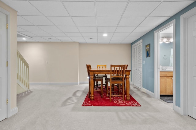 carpeted dining space featuring recessed lighting, a paneled ceiling, and baseboards