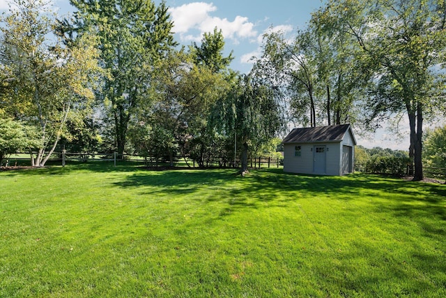 view of yard featuring an outbuilding, fence, and a storage shed