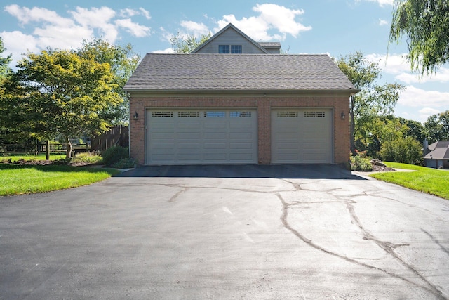 garage featuring driveway and fence