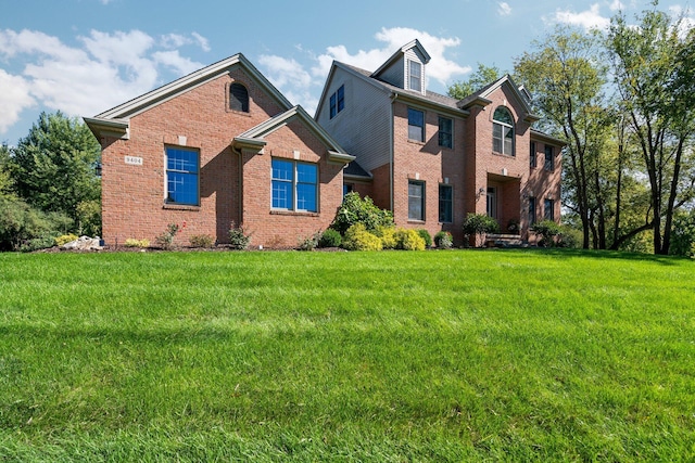 view of front of house featuring a front yard and brick siding