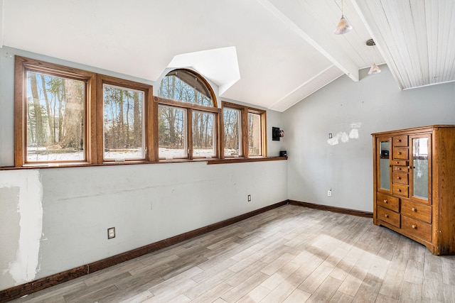 unfurnished room with lofted ceiling with beams, light wood-style flooring, and baseboards