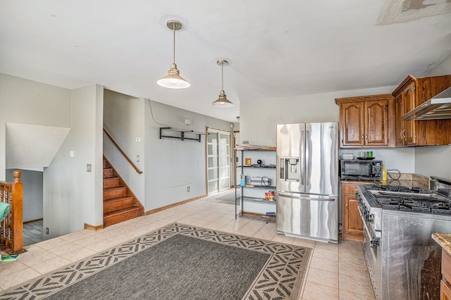 kitchen featuring light tile patterned floors, dark countertops, appliances with stainless steel finishes, brown cabinets, and pendant lighting