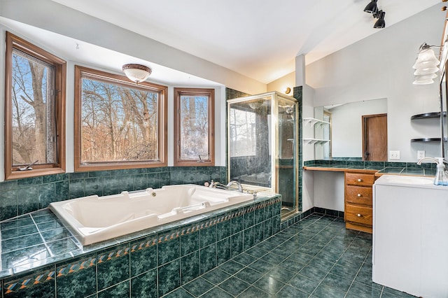 bathroom featuring lofted ceiling, a wealth of natural light, a stall shower, vanity, and a whirlpool tub