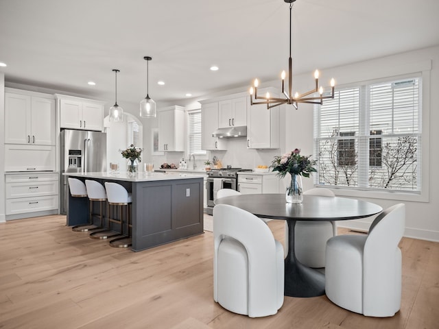 dining room with recessed lighting, an inviting chandelier, light wood-style flooring, and a healthy amount of sunlight