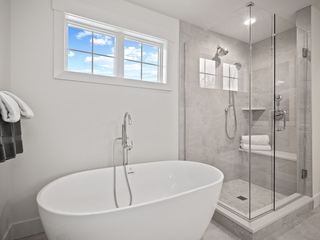 bathroom with a shower stall and a freestanding bath