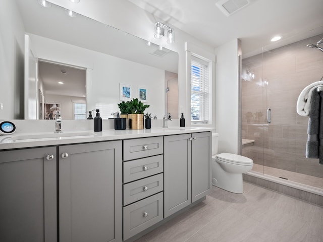 full bath featuring visible vents, a shower stall, toilet, double vanity, and a sink