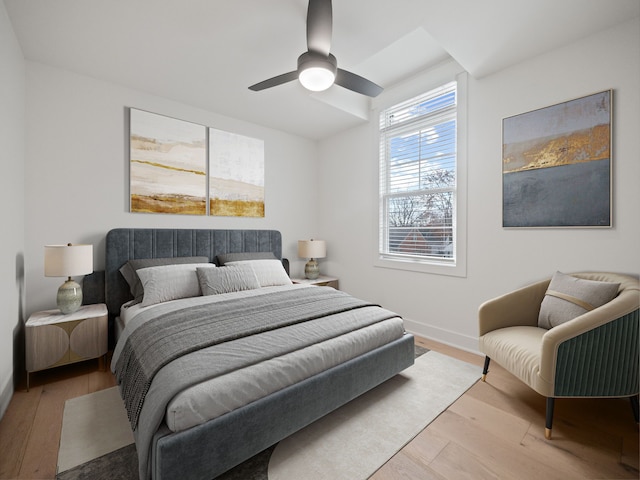 bedroom featuring ceiling fan, baseboards, and wood finished floors