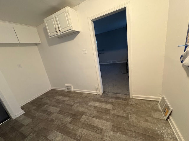 laundry room with dark wood-style flooring, visible vents, and baseboards