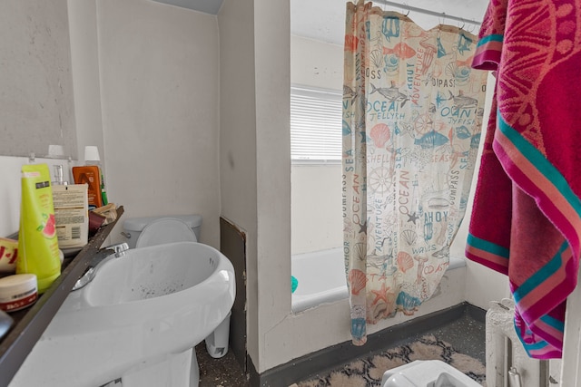 full bathroom featuring toilet, shower / tub combo with curtain, and a sink